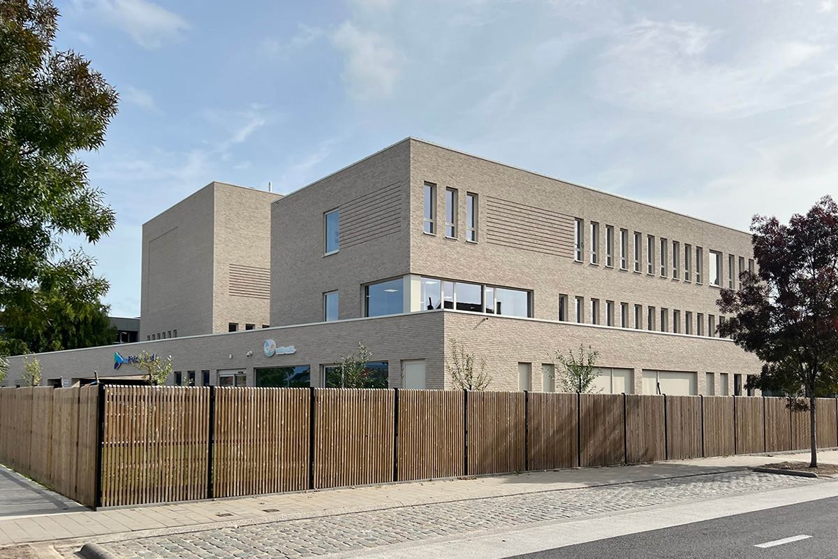 Modern bakstenen gebouw van drie bouwlagen, gezien vanaf de straat