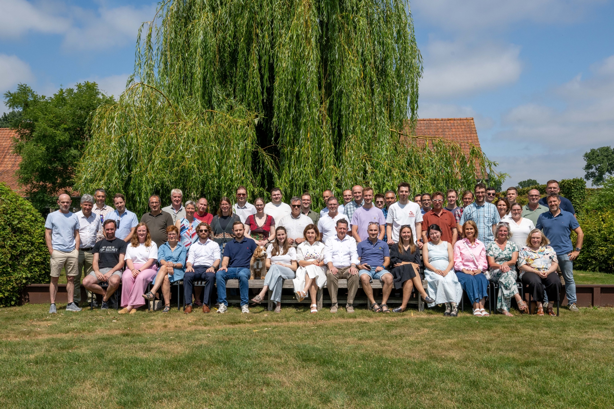 Groepsfoto van het team van De Klerck Engineering in de tuin