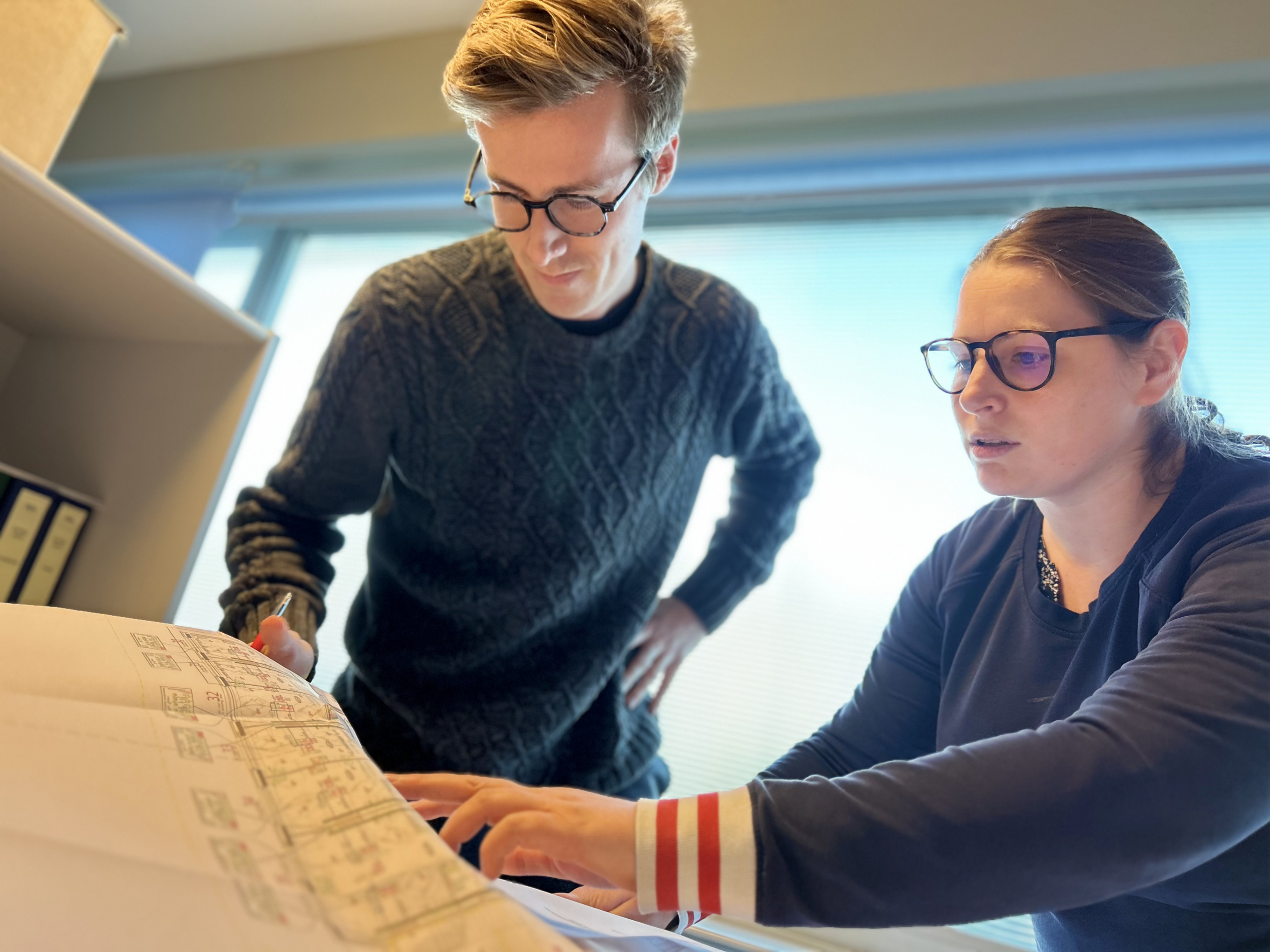 Twee collega’s bekijken samen een plan