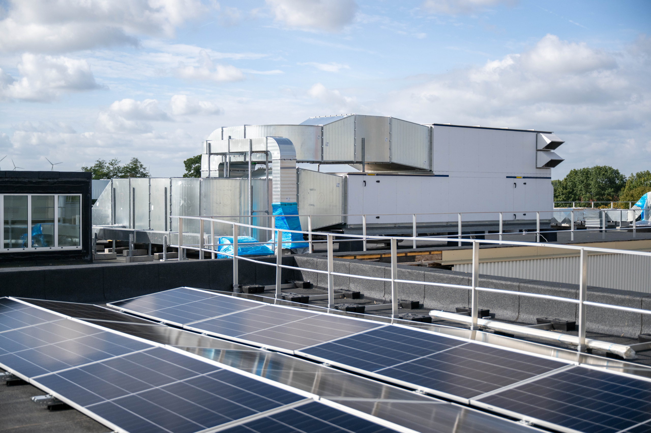 Zonnepanelen en luchtgroepen op een plat dak