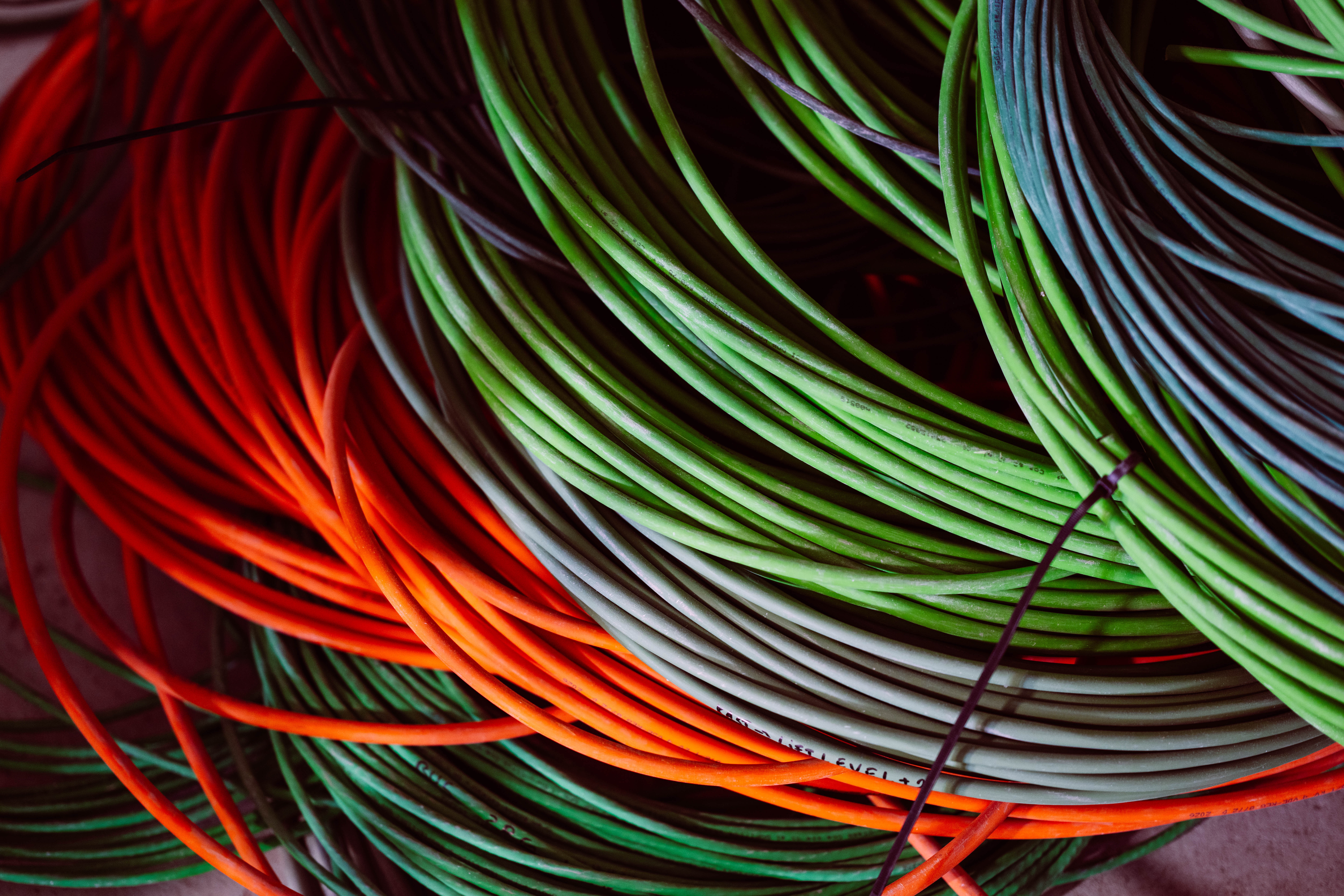 Rollen oranje, groene en grijze datakabels