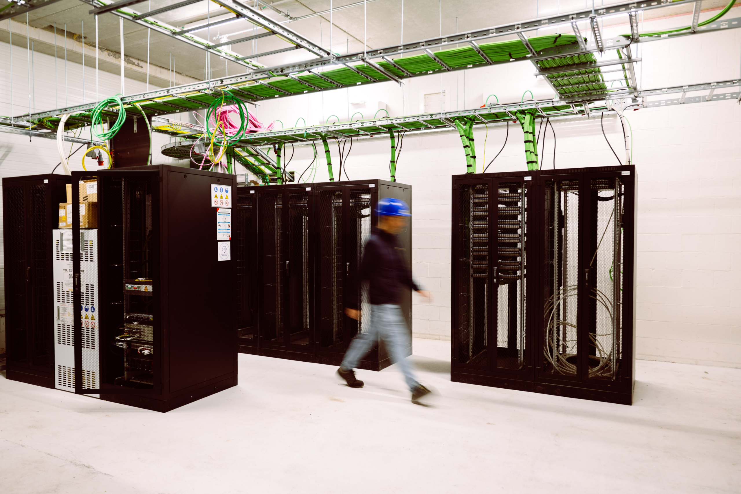 Serverruimte met zwarte racks en groene kabelgoten